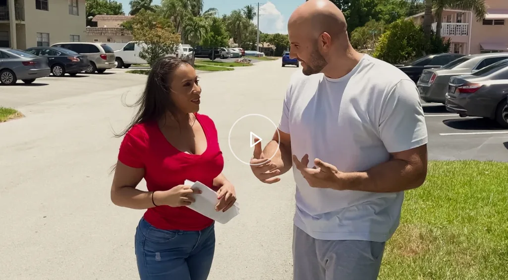 Scena di Lil Humpers 2025 con Carmela Clutch che distribuisce volantini in strada mentre parla con JMac, dando il via a un incontro hot tipico della serie MILF.