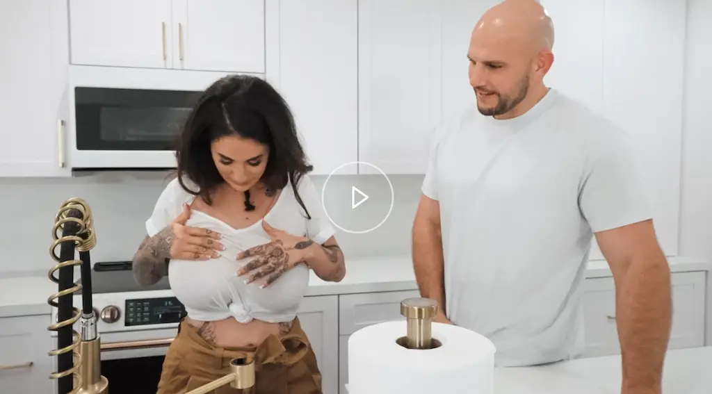 Scena di Mommy Got Boobs 2025 con Arabelle Raphael e JMac, episodio Get Outta Those Wet Clothes con atmosfera giocosa e sensuale tipica delle MILF Reality Kings.