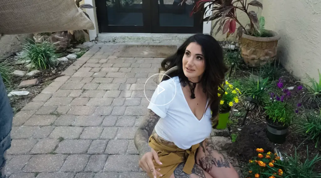 Mommy Got Boobs 2025 con Arabelle Raphael nei panni della giardiniera sensuale e JMac, in una tipica scena MILF della serie Reality Kings con atmosfere di vicinato piccanti.