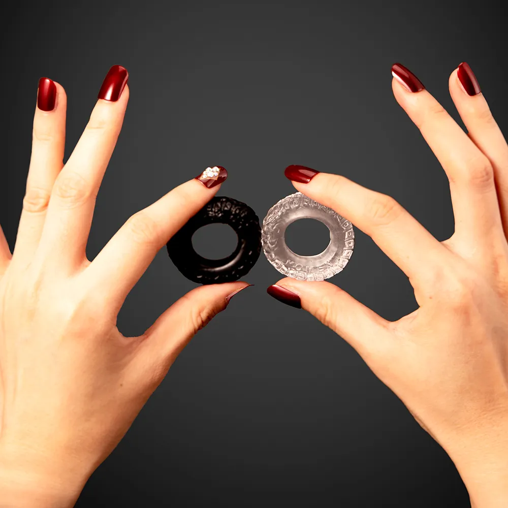 Mani che tengono due anelli fallici in silicone, sex toys sotto 30 euro ideali per giochi sul sesso di coppia